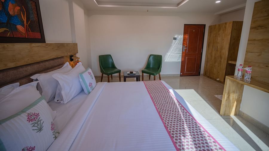 Bedroom with double bed, two chairs, and soft lighting at Clarks Collection, Somnath.
