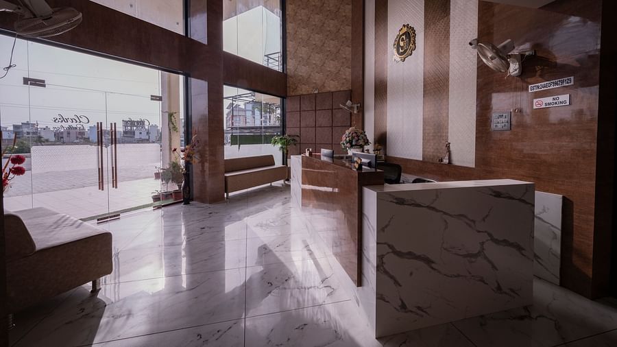 Elegant lobby of Clarks Collection Somnath with marble flooring, modern interiors, glass doors, and seating arrangement near the reception.