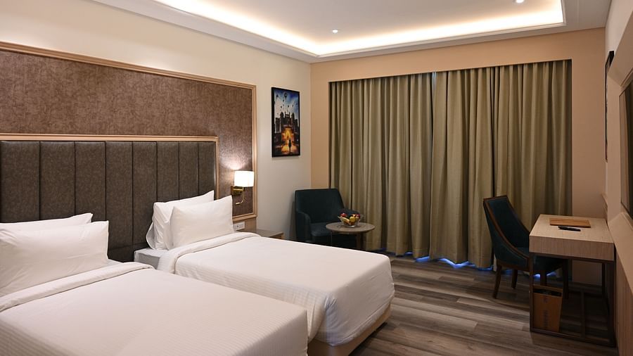 A hotel room with a well-lit interior, comfortable twin beds, and a stylish work area - Sarovar Portico, Ajmer
