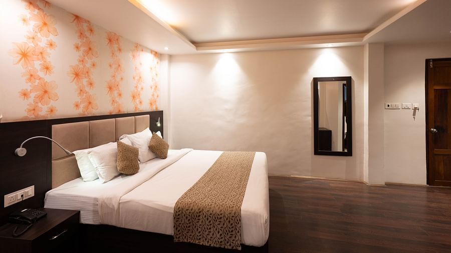 A bedroom featuring a large mirror and floral-designed wallpaper at Avianna Hungry Jack, Gangtok.