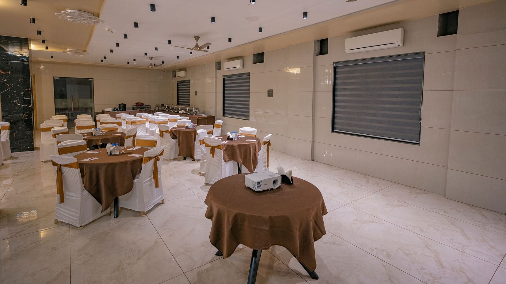 Round table setup with covers, fan, ac and chairs at Clarks Collection Somnath.