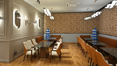 Modern dining room with long tables, soft lighting, and a patterned accent wall at Pride Elite Raipur.