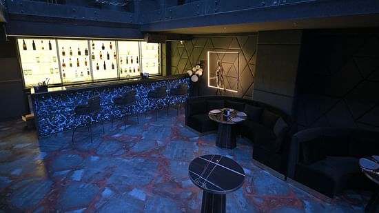 A well-lit bar with bottles neatly arranged on racks at Clarks Collection Grand Sapphire, Ajmer.