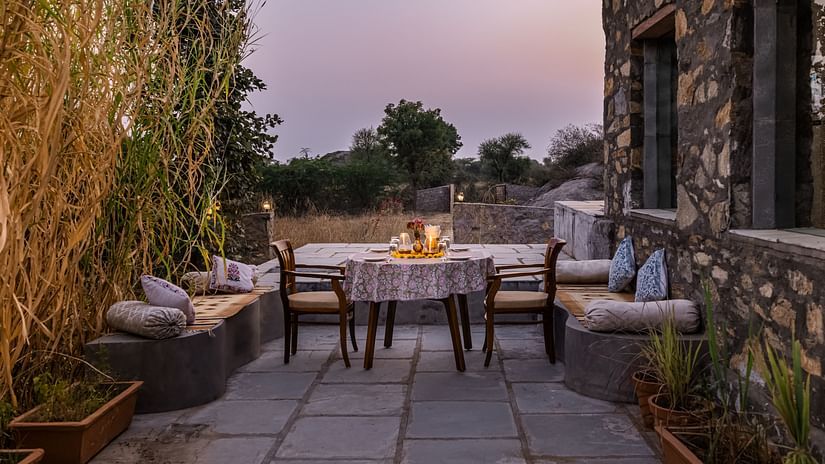Outdoor dining space with a table and chairs, with a pleasant ambience in a beautiful setting