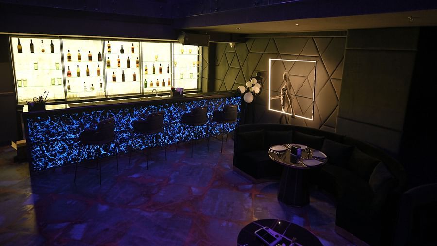 A well-lit bar with bottles neatly arranged on racks at Clarks Collection Grand Sapphire, Ajmer.