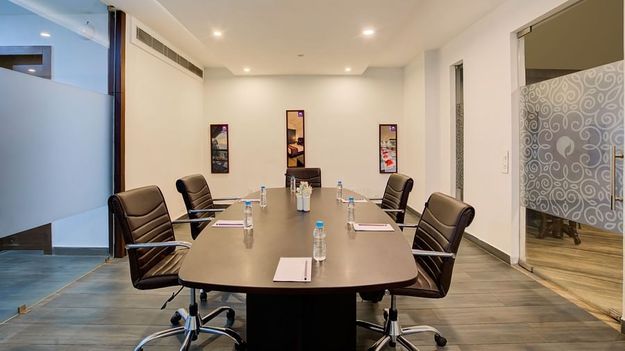 Private meeting space with a sleek conference table, stylish wall art, and ambient lighting at Voyage Milestone Hotel and Banquet Siliguri