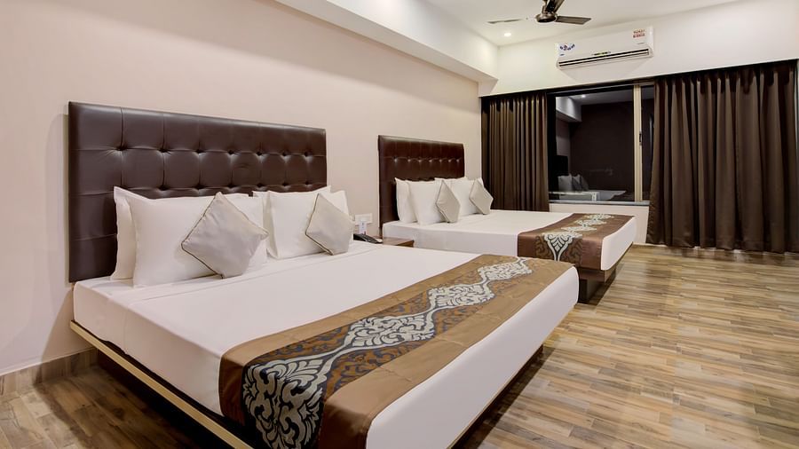 Contemporary room with two large beds, stylish headboards, and wood-patterned flooring at Voyage Milestone Hotel and Banquet Siliguri