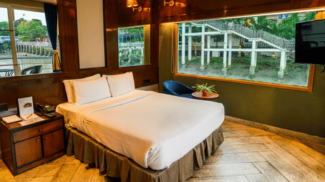 A double bed with side tables inside one of the rooms at Polo Floatel Kolkata