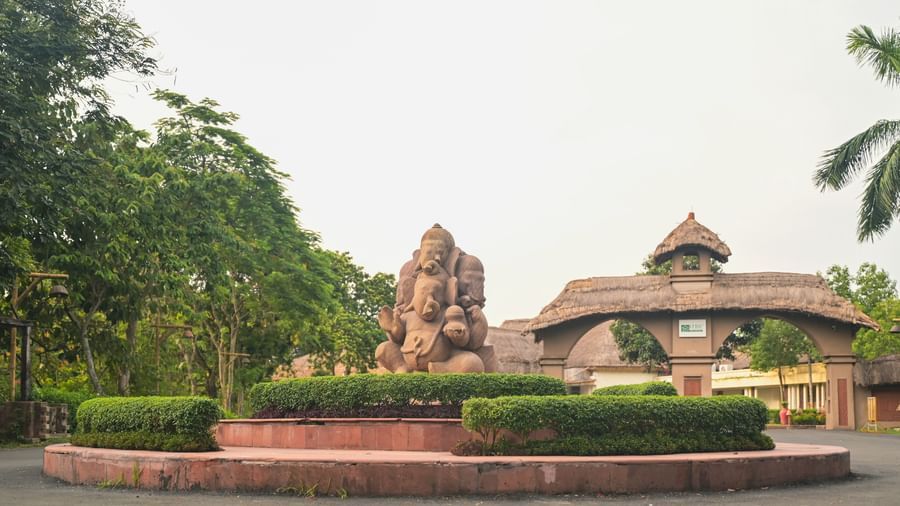The entrance to Vedic Village Spa Resort featuring a mud sculpture and clay arch ways leading to the property.