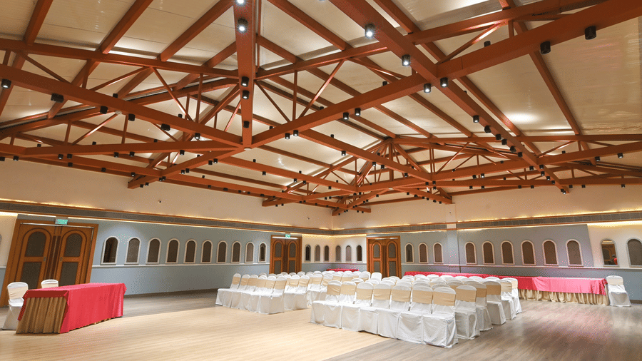 Spacious banquet hall at Vedic Village Spa Resort with exposed wooden ceiling beams, open event space, and flexible seating arrangements for conferences and celebrations.