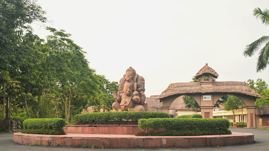 The entrance to Vedic Village Spa Resort featuring a mud sculpture and clay arch ways leading to the property.