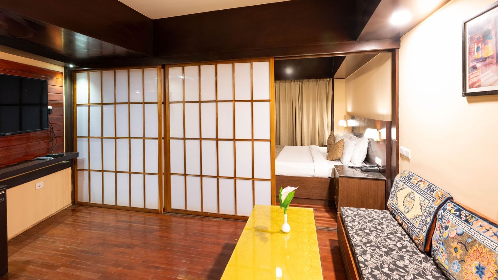 A spacious bedroom with a living area featuring a sofa and a table at Avianna Hungry Jack, Gangtok.