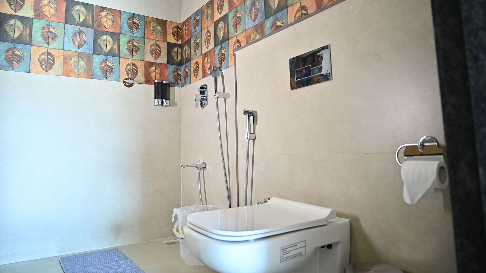 Bathroom with a shower area featuring colourful leaf-patterned tiles, modern fittings, and a clean design at TGI Livancia Hillside