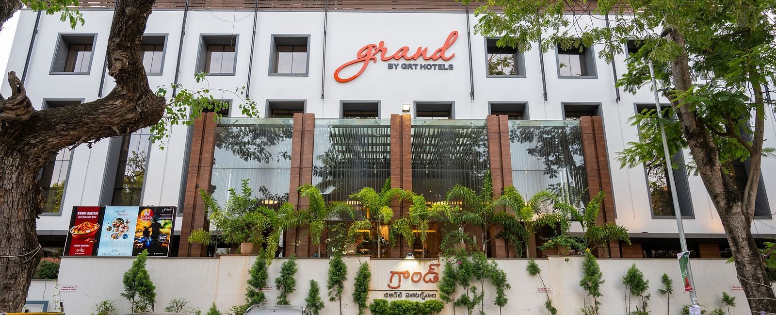 parking space of Grand Kakinada by GRT Hotels covered with plants and trees