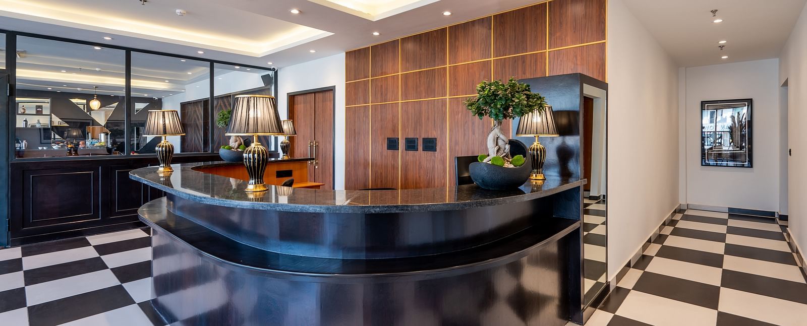Front Desk at Vishranti Hotel, Dehradun with plants kept on the table and ambient lighting. 