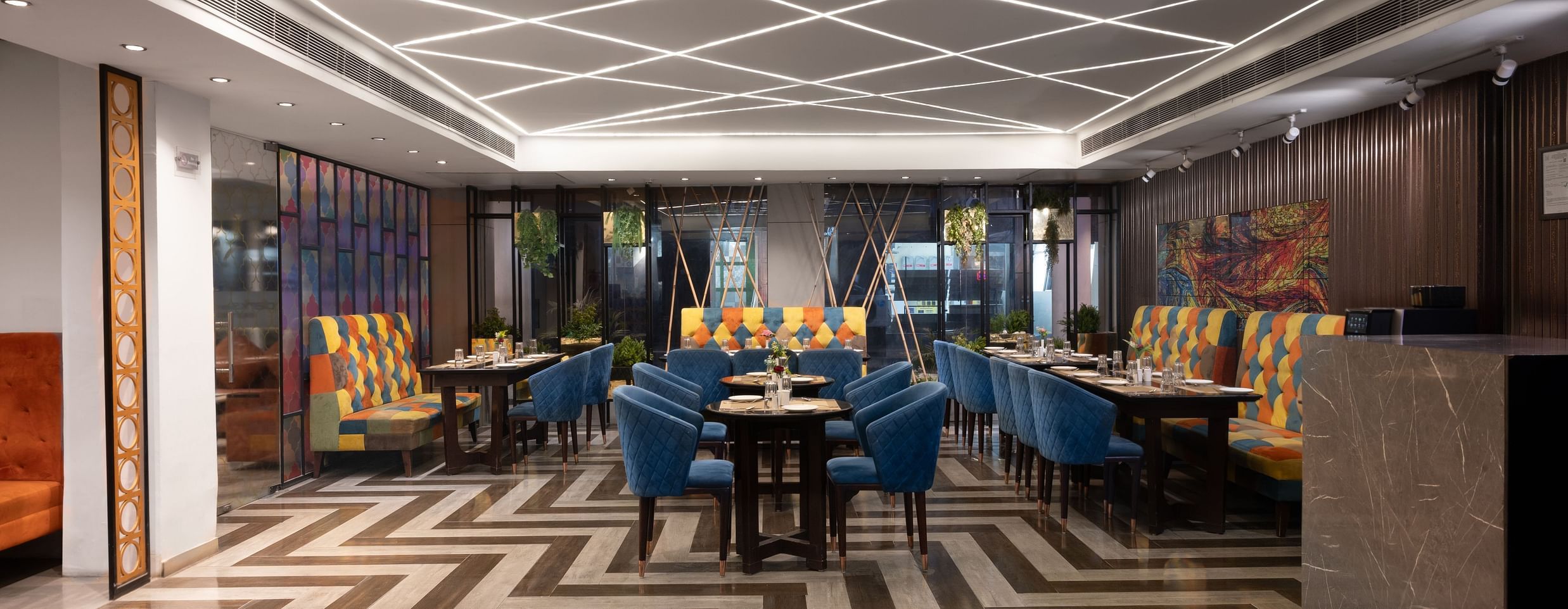 A stylish dining area featuring modern decor, with seating arranged and zigzag pattern on the floor - Clarks Inn Express, Near Jammu Bari Brahmana Railway Station