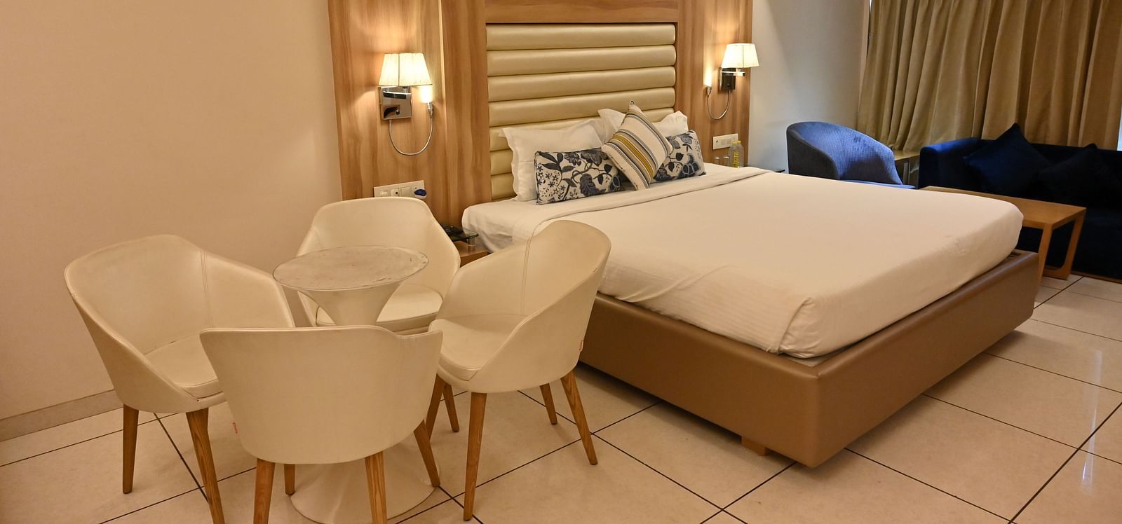 Inviting room at Rang Lords Inn Bharuch, with a neatly made bed, seating, and warm bedside lamps