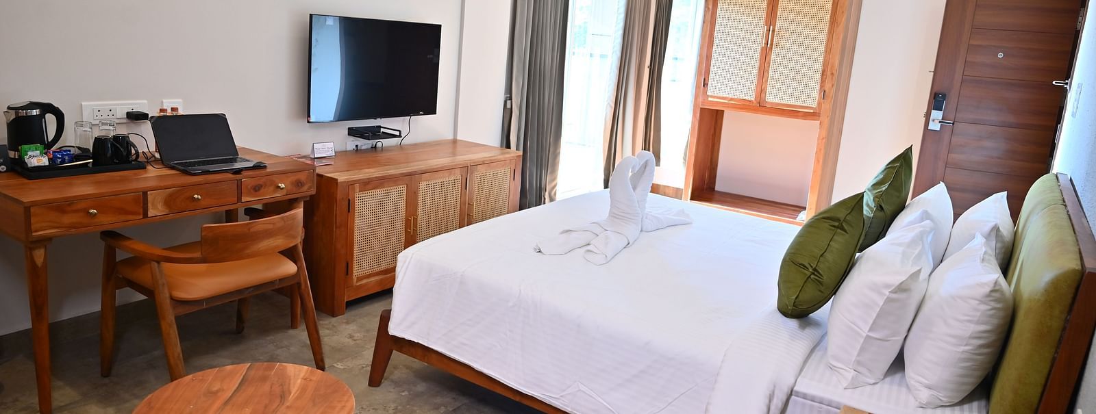 Spacious Club Suite with a comfy bed, a wooden desk, a TV, a wardrobe, and large windows letting in natural light at TGI Livancia Hillside
