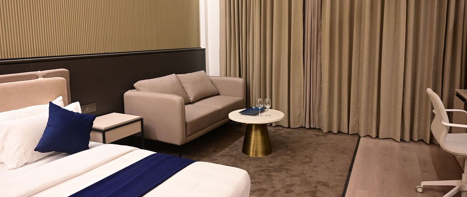 image of the imperial guest suite at club charholi with a double bed and a seating area in the corner