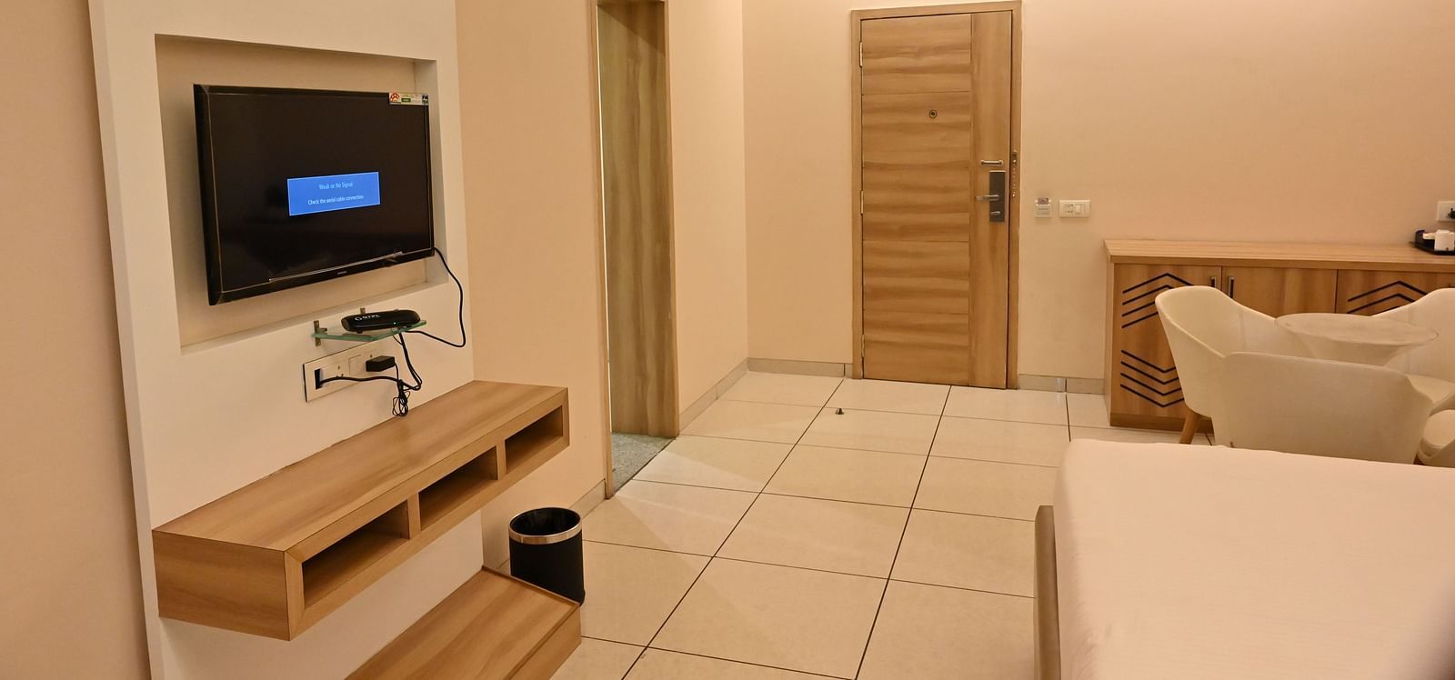 Hotel room with a TV, bed, and side table, highlighting the amenities at Rang Lords Inn