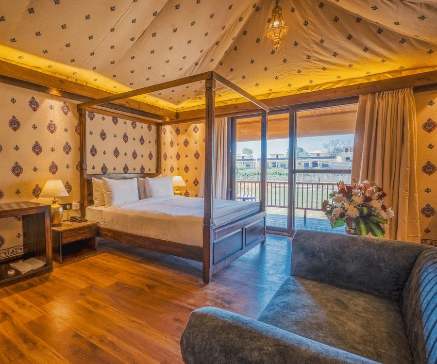 A Premium Duplex Tent featuring  a plunge swimming pool, a sofa set, with centre table, and a flight of wooden stairs at The Baagh Ananta Elite, Ranthambore