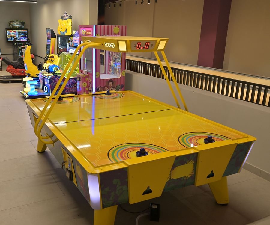 A bright contrast air hockey table along with other arcade machines in the room - Clarks Safari, Haridwar