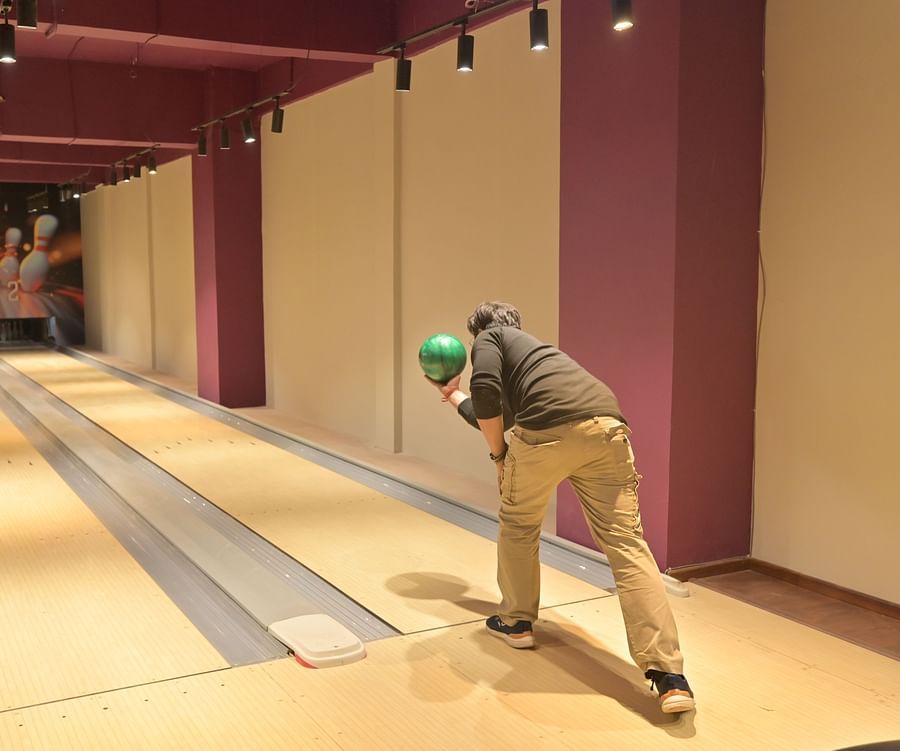 A man throwing a bowling ball in an alley, captured mid-action - Clarks Safari, Haridwar