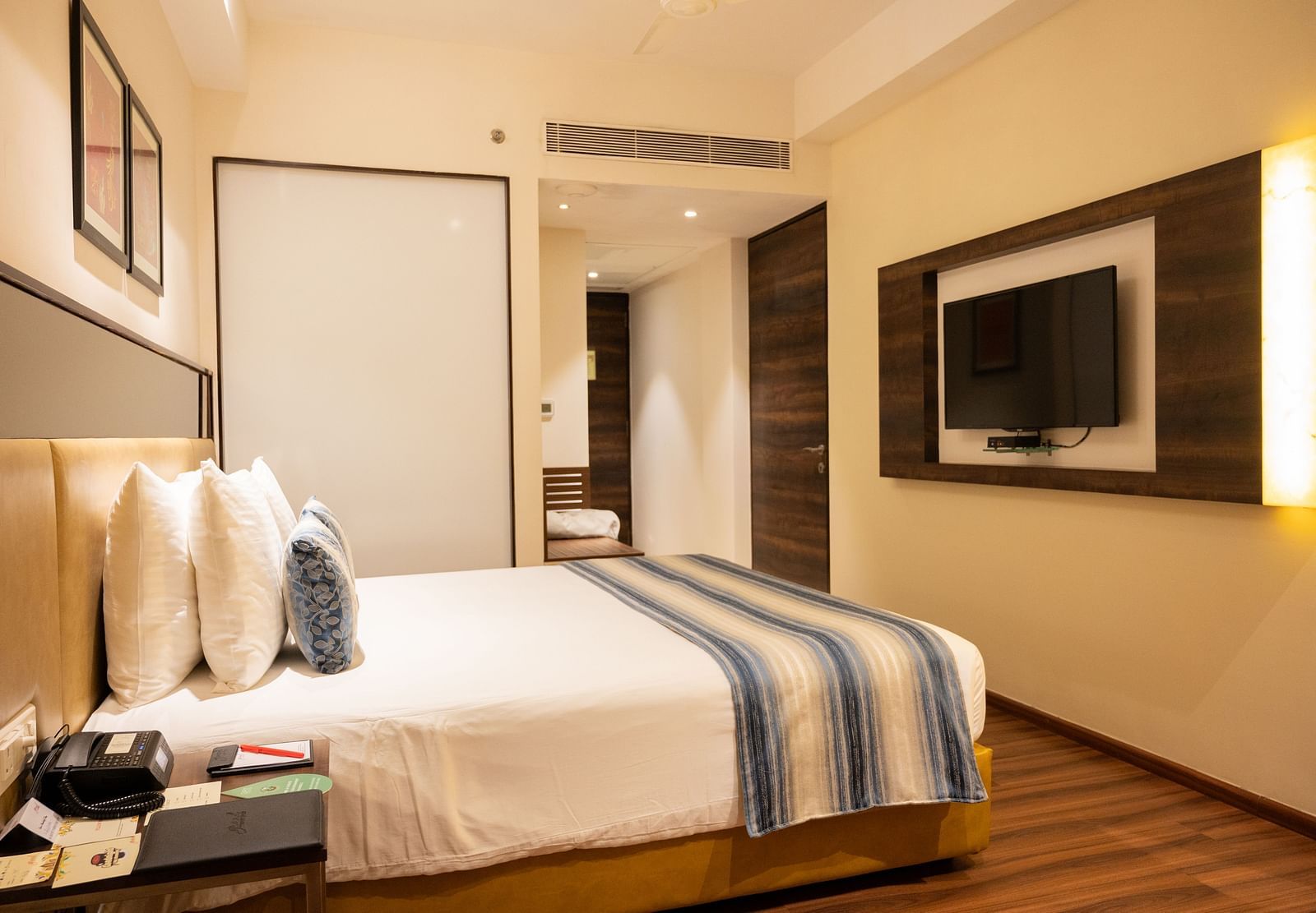 side view of a bedroom with a wall mounted television at Grand Kakinada by GRT Hotels