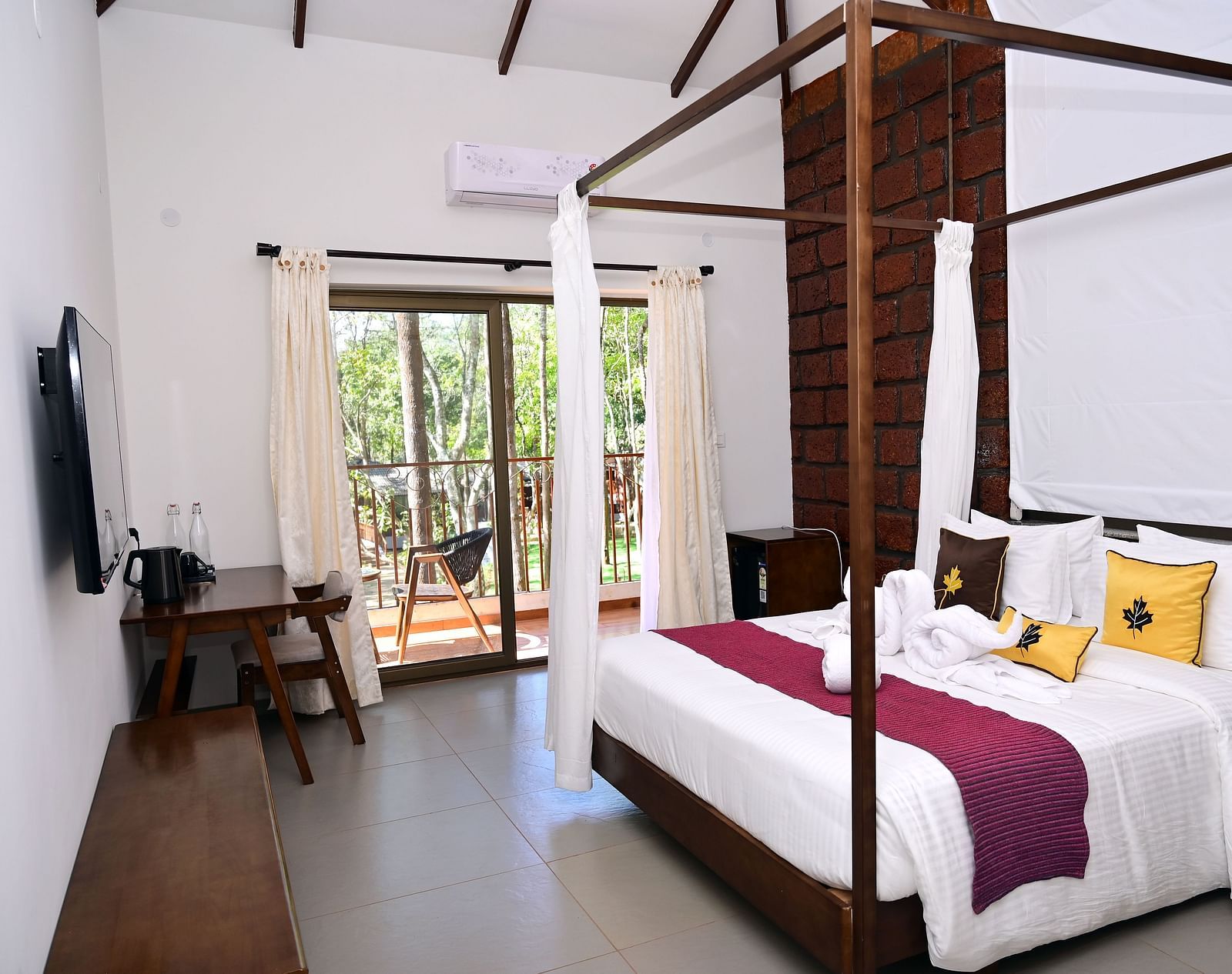An image of a Premium Cottage featuring a poster bed, a flat TV screen, a work desk and chair, and a balcony - TGI Redolent Resort, Kushalnagar, Coorg