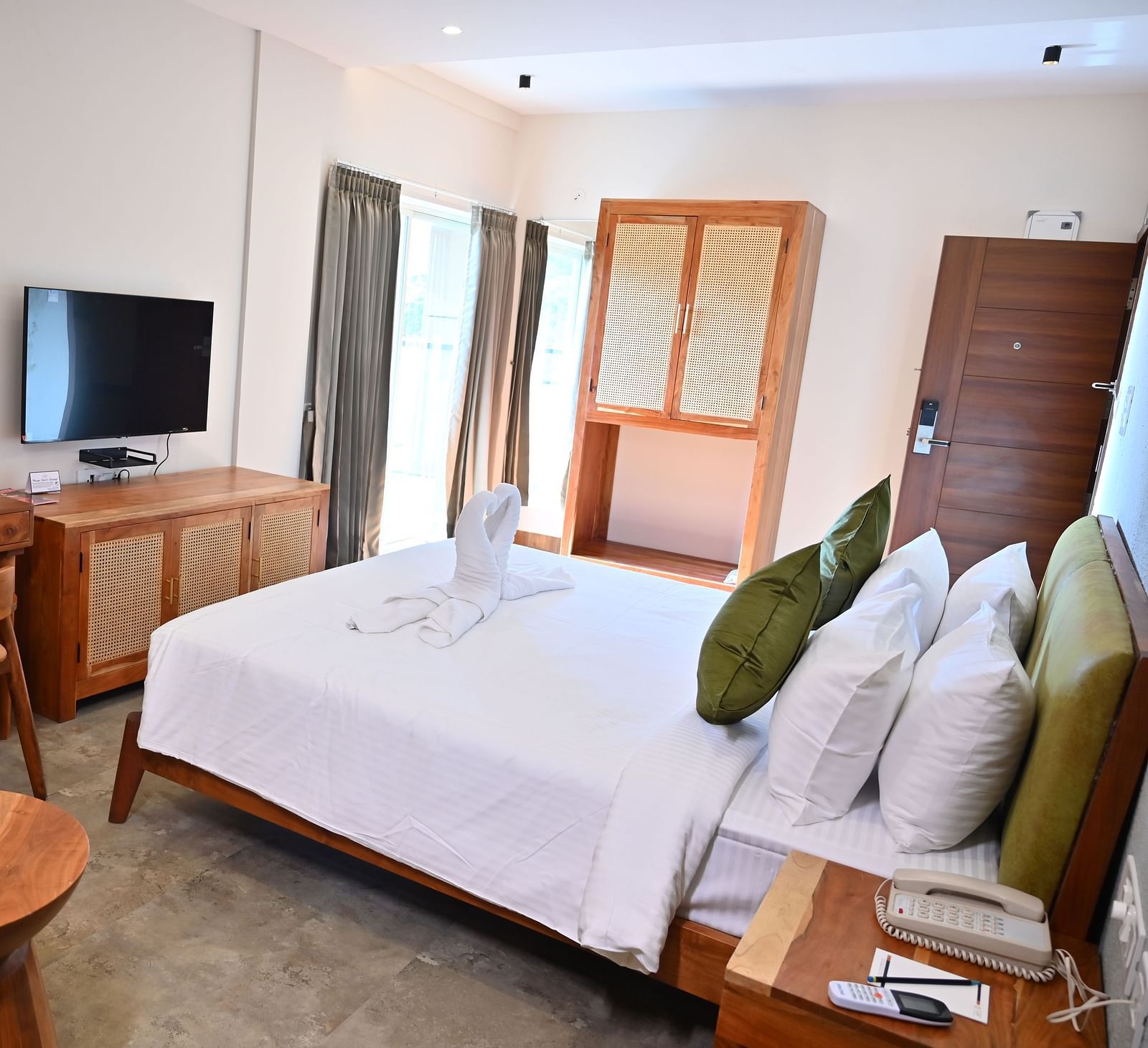 Spacious Club Suite with a comfy bed, a wooden desk, a TV, a wardrobe, and large windows letting in natural light at TGI Livancia Hillside
