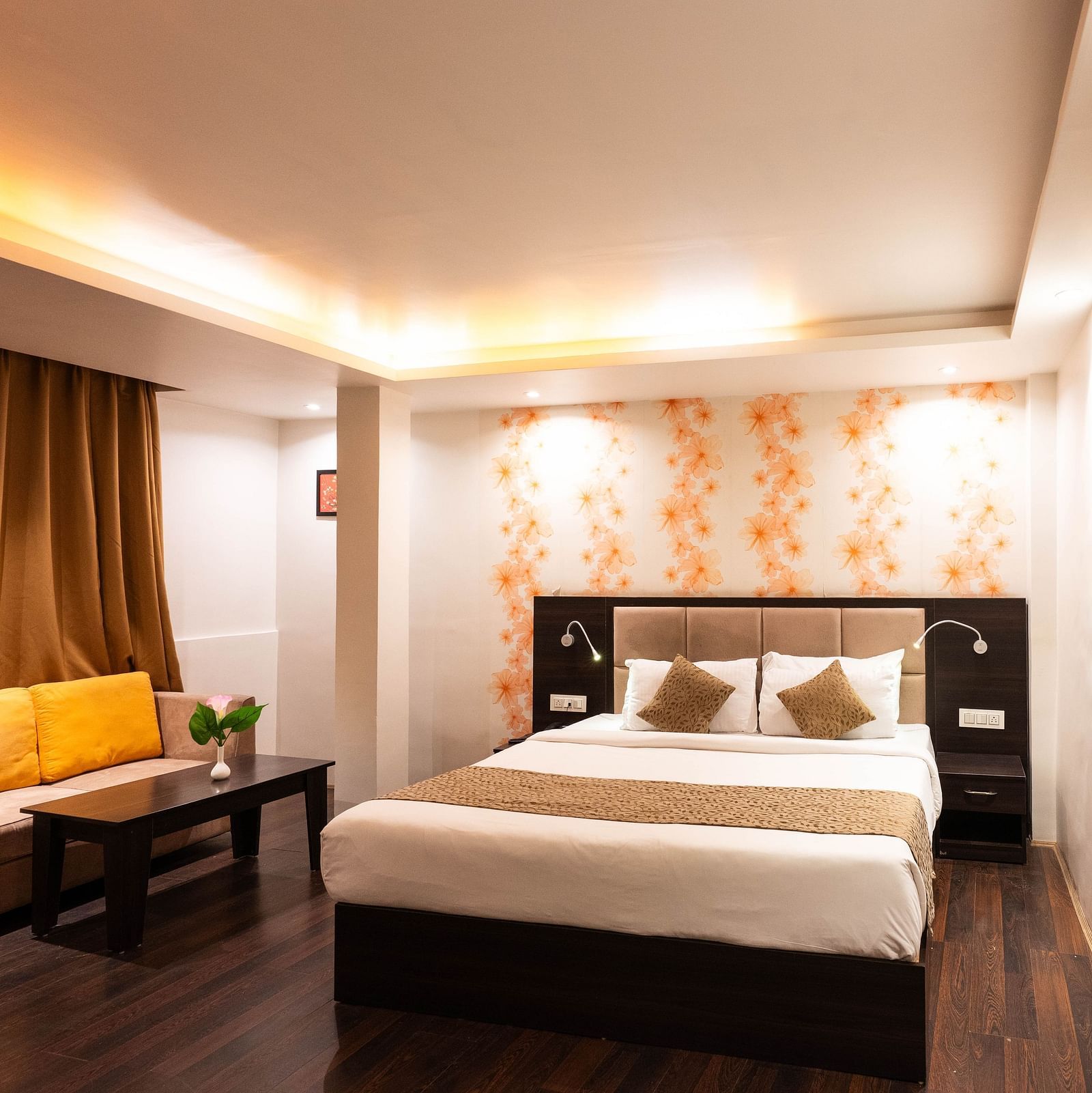 A bedroom with a seating arrangement beside it, and a curtain drawn over the window at Avianna Hungry Jack, Gangtok.