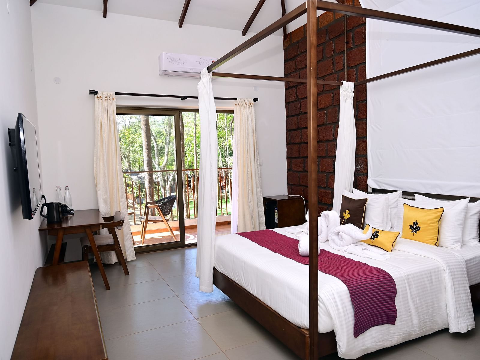 An image of a Premium Cottage featuring a poster bed, a flat TV screen, a work desk and chair, and a balcony - TGI Redolent Resort, Kushalnagar, Coorg