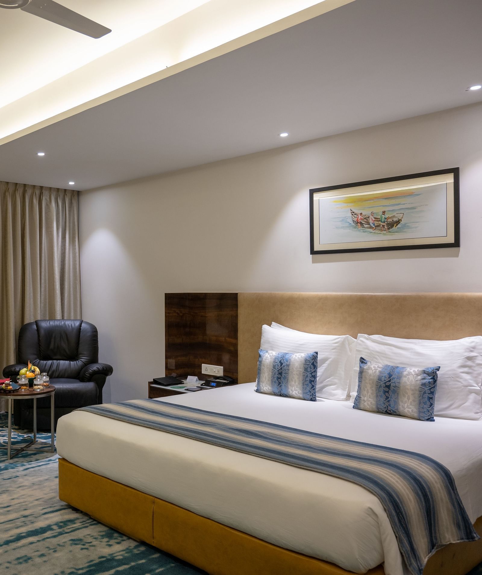 an image of a bedroom with a paining on top of the headboard at Grand Kakinada by GRT Hotels