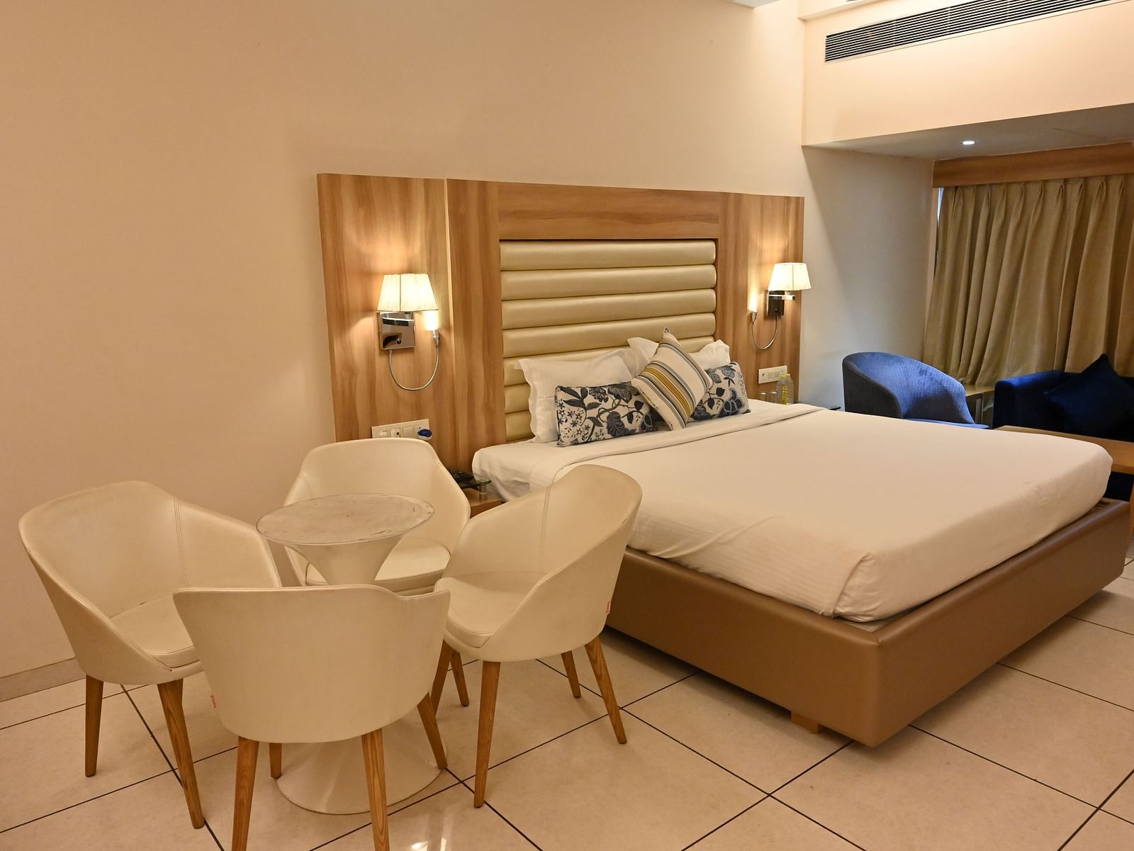 Inviting room at Rang Lords Inn Bharuch, with a neatly made bed, seating, and warm bedside lamps
