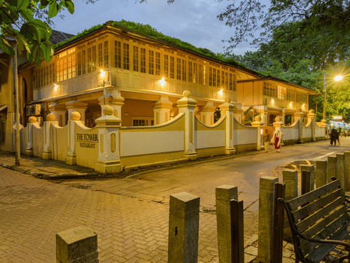 Facade of The Tower House - 17th Century, Cochin, in the dusk with lit up building and streets