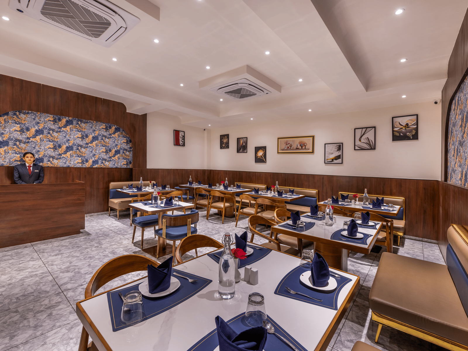 Spacious dining hall with neatly arranged tables set for guests at the restaurant of Lords Studio Inn, Jamnagar.