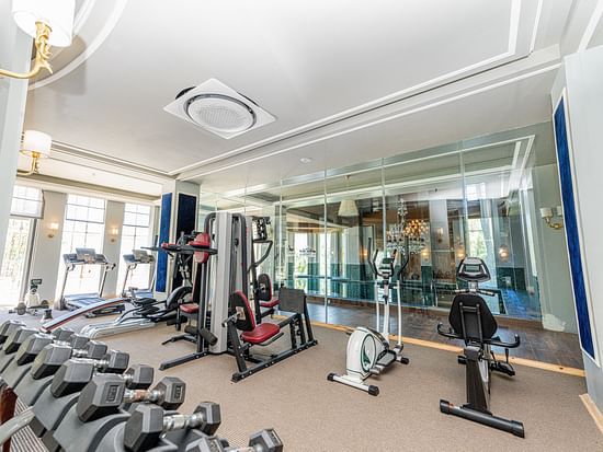 A gym with modern machines like cycling machine, treadmill and a dumbbell rack - The Manor Luxury Hotel, Shimla