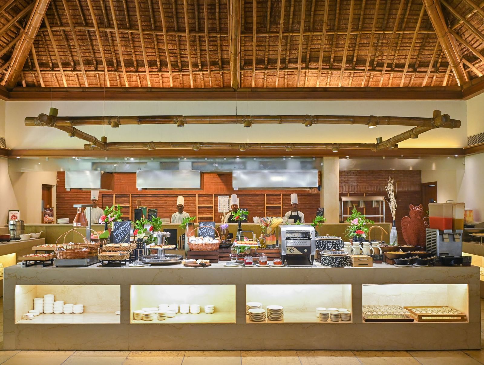 Buffet Counter in Yagna at Vedic Village Spa Resort, featuring high ceilings and chefs lined up behind the counter.
