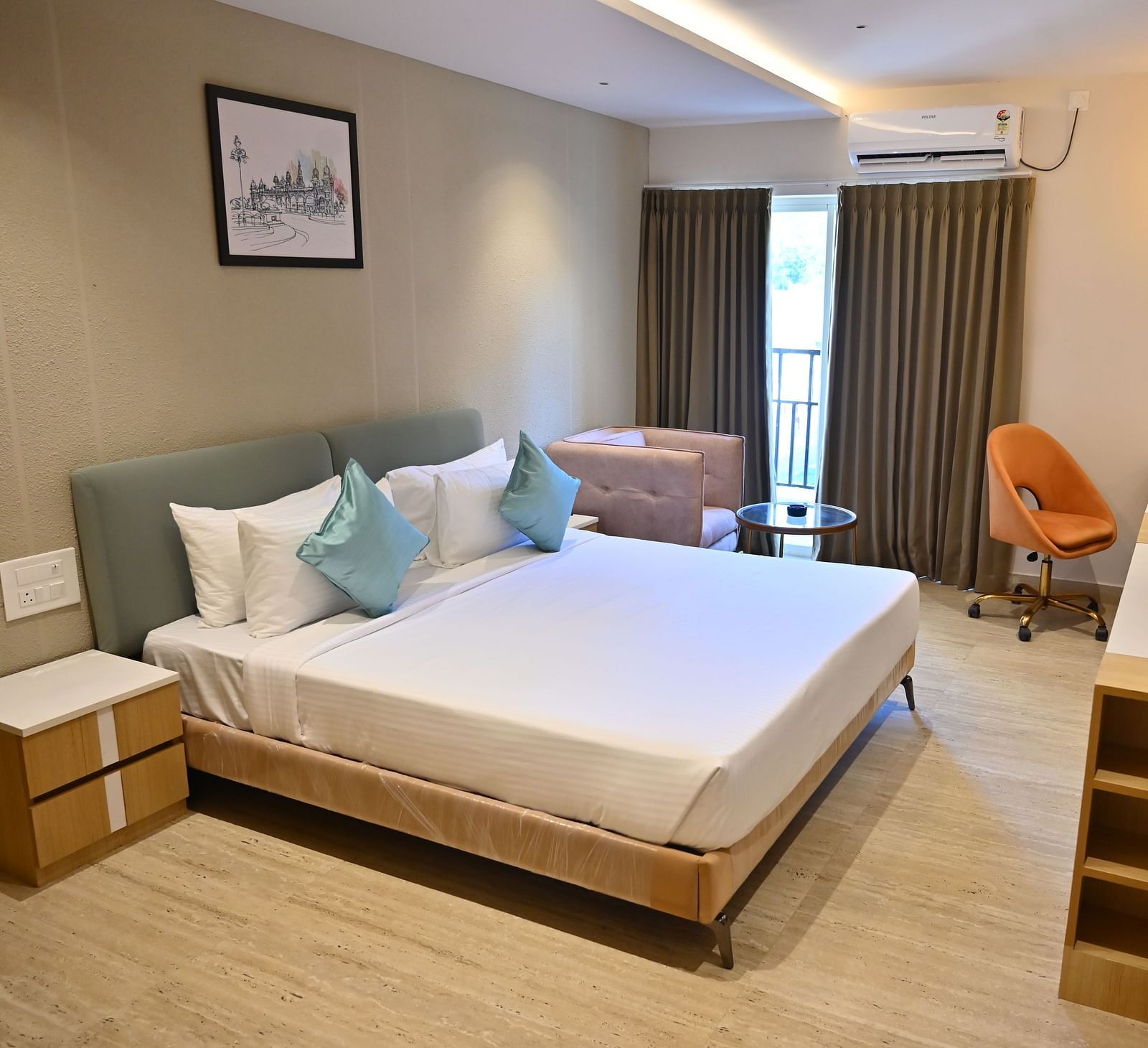 Bright and airy premium room with a big bed, soft chairs, and curtains over large windows, offering plenty of light and modern features - Livancia Hillside
