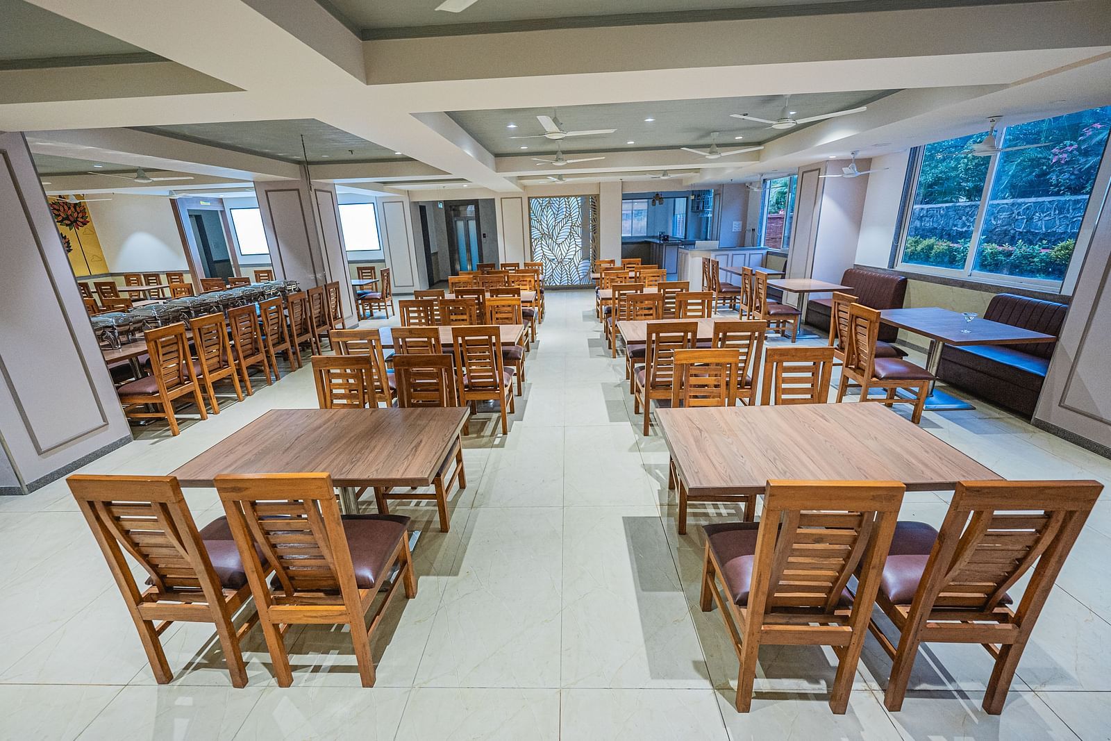A bright dining area with neatly arranged wooden tables and chairs at Lotus Leaf Boutique Hotel.