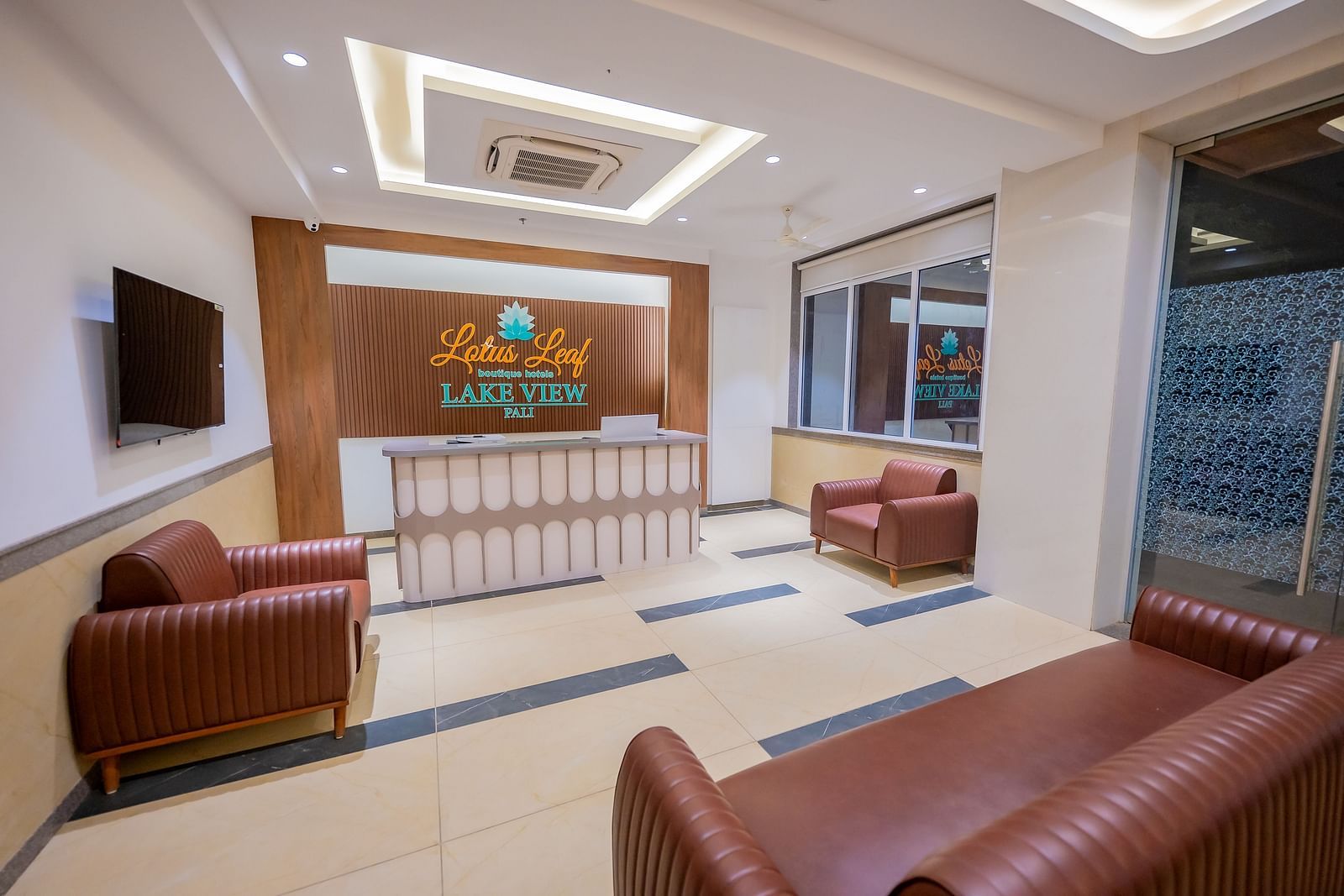 A modern hotel reception area with comfortable seating, a counter, and stylish decor.
