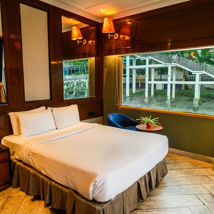 A double bed with side tables inside one of the rooms at Polo Floatel Kolkata