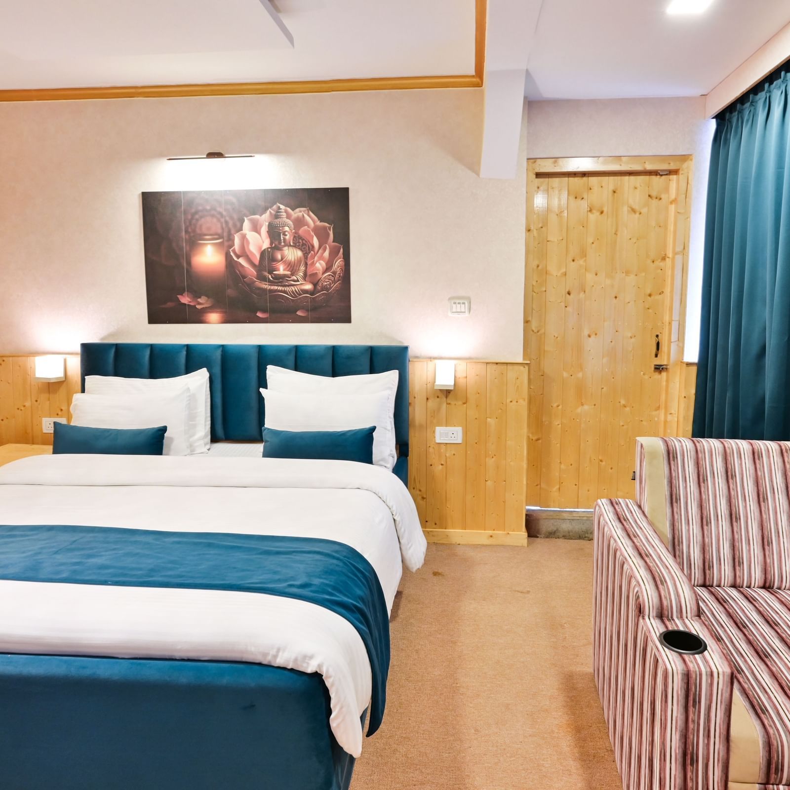 The suite features a spacious bed, large windows stretching along one side of the room, comfortable cushioned furniture, and warm lighting at Avianna Seven Seas, Darjeeling4