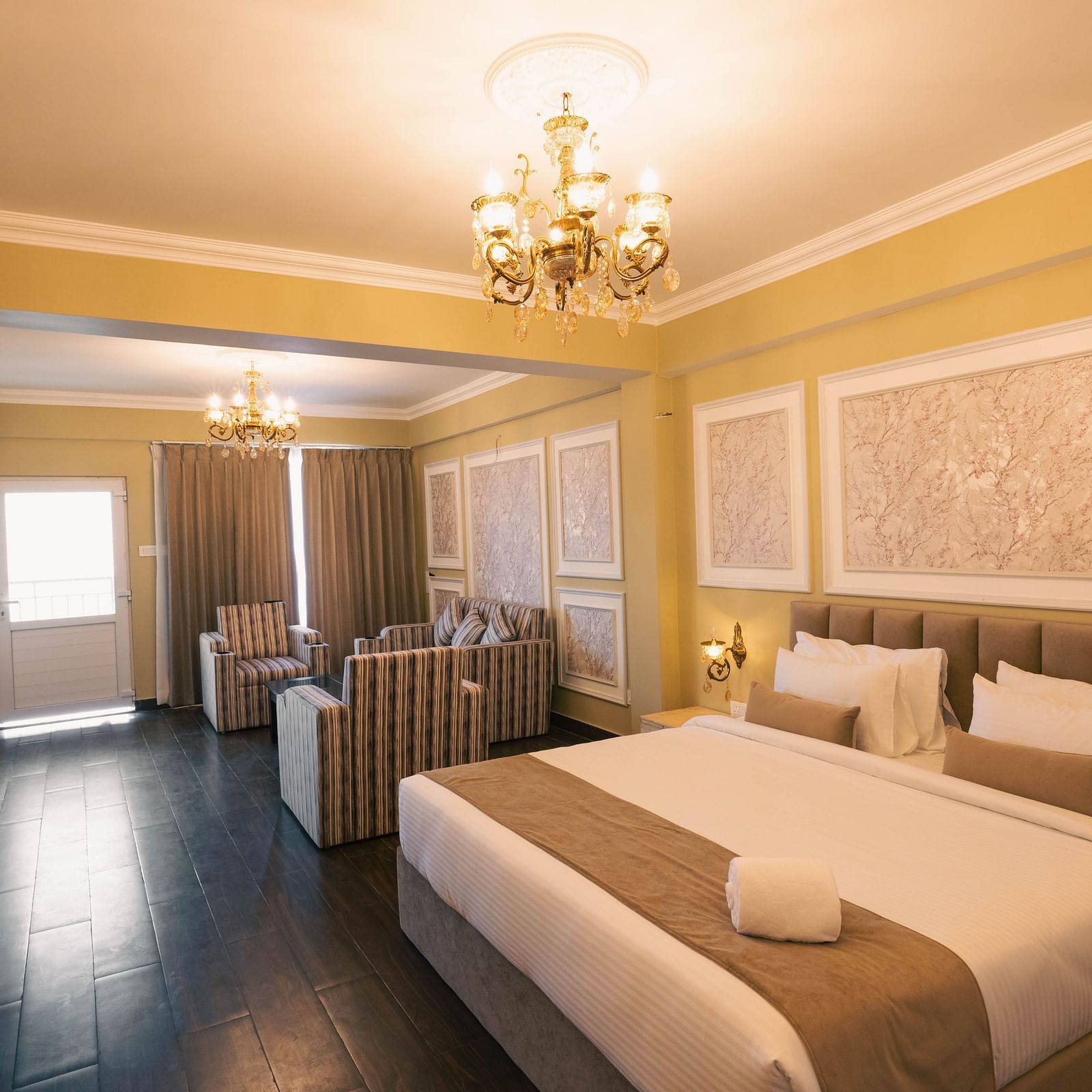 Golden Eagle Room with elegant decor, featuring a king size bed, plush seating area, chandeliers, and soft ambient lighting at Avianna Windy House Wellness Retreat & Spa