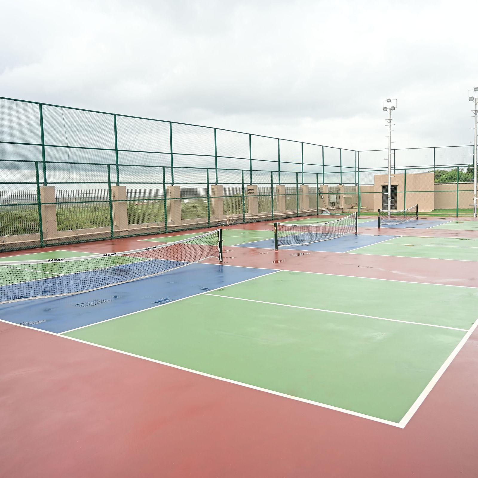 image featuring three distinct tennis courts at club charholi, pune