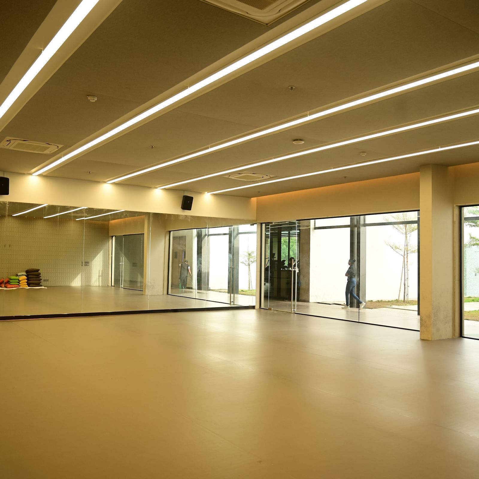 image of a spacious dance studio with hugh glass windows at club charholi, pune