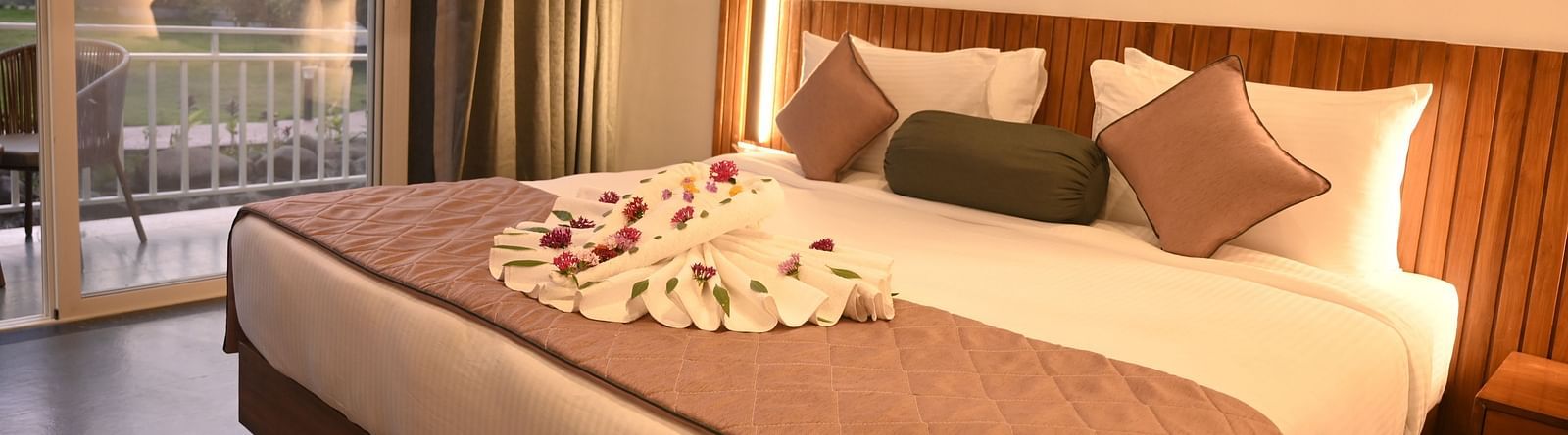 Side view of a double bed at the Kutumbh Suite at Mango Leaf Lake Resort, Pune