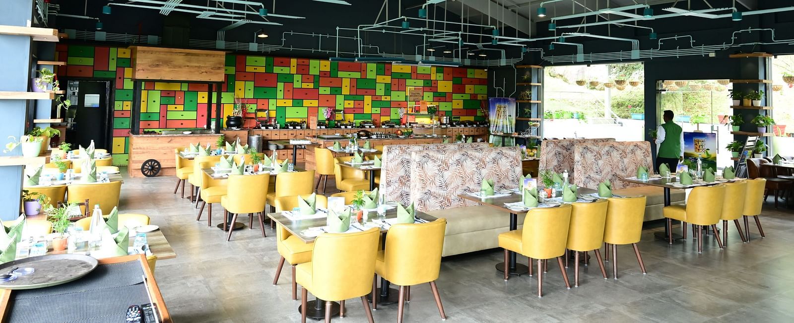 An image of a restaurant with seating arrangement, cutlery, and decorative items - GReaT trails Kodaikanal by GRT Hotels