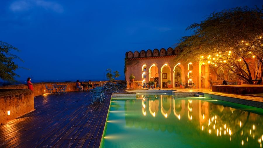 A vibrant blue pool with the resort at the background - Hill Fort Kesroli Alwar Rajasthan