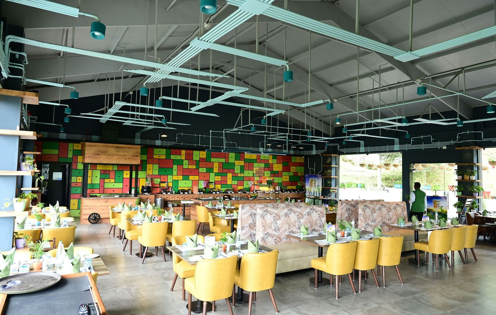 An image of a restaurant with seating arrangement, cutlery, and decorative items - GReaT trails Kodaikanal by GRT Hotels